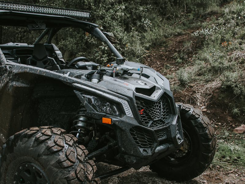 RECON TRAIL ATV & UTV Off-Road Performance UTV equipped with RECON TRAIL off-road tires driving through a rugged forest trail.